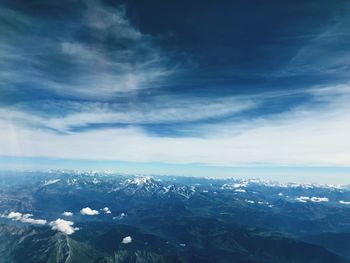 Scenic view of snowcapped mountains against blue sky