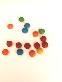 High angle view of multi colored candies against white background