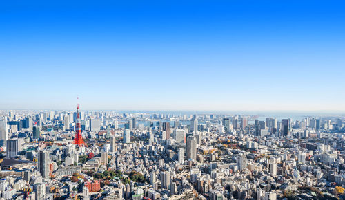 Aerial view of city buildings against blue sky