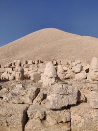 Text on rocks against clear blue sky