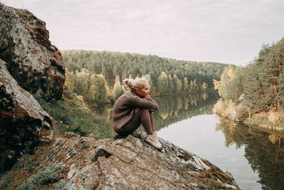 Rear view of woman standing by lake