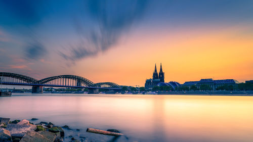 View of bridge over river at sunset