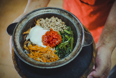 High angle view of person holding food in bowl