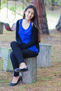 Portrait of a smiling young woman sitting outdoors