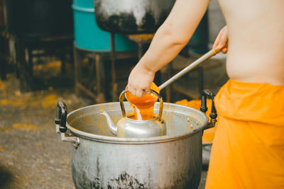 Midsection of man preparing tea