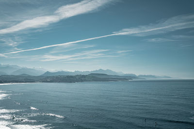 Scenic view of sea against sky with mountains in the background