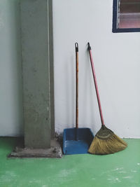 Broom with dust pan by wall