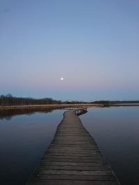 Walkway over pond and full moon