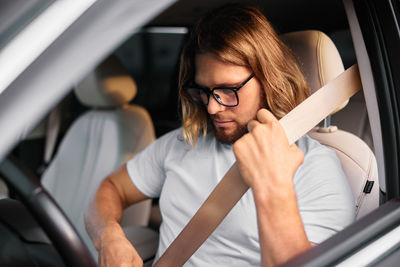 Portrait of young woman sitting in car