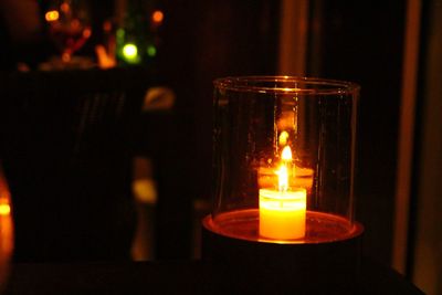 Close-up of illuminated tea light candle on table