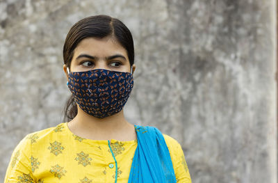 An indian woman wearing homemade cotton nose mask and looking left during corona virus pandemic