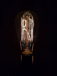 Close-up of illuminated light bulb in darkroom