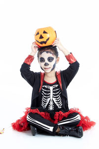 Full length of boy wearing red mask against white background