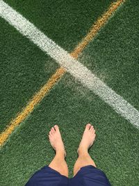 Low section of man standing on soccer field