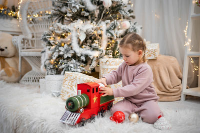 Portrait of boy playing with christmas tree at home