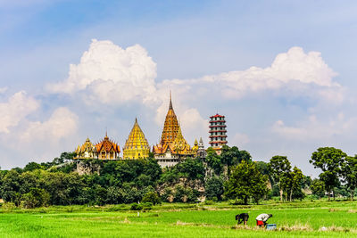 Traditional building on field against cloudy sky