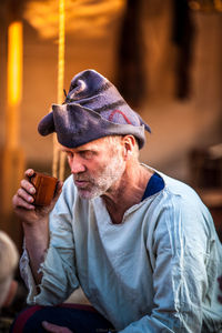 Mature man having drink while sitting outdoors