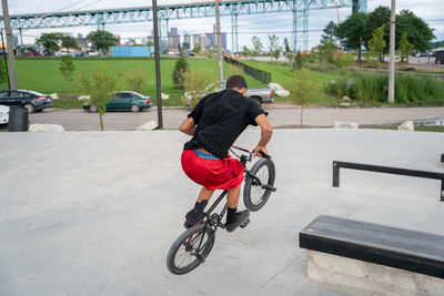 Rear view of man riding bicycle on city