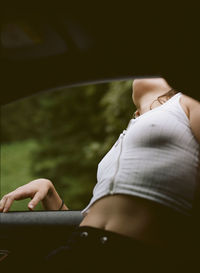 Midsection of woman sitting in car