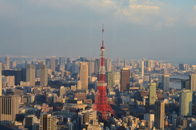 Tokyo tower amidst buildings against sky in city