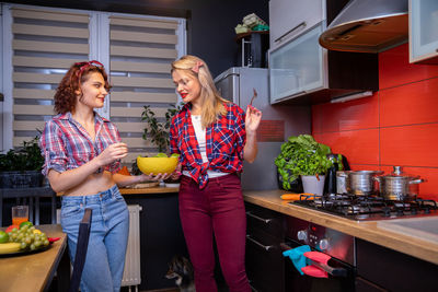 Female friends using digital tablet while sitting at home