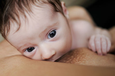 Cropped image of mother feeding cute baby girl