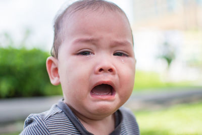 Close-up portrait of cute baby boy crying