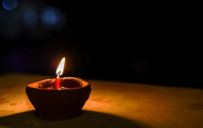 Close-up of lit candle in the dark