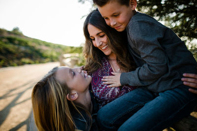 Mom hugging son and daughter in southern california