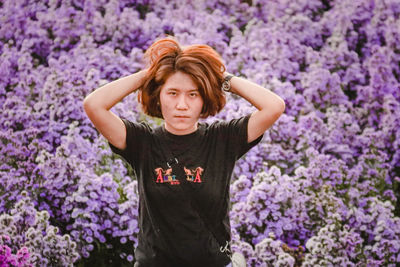 Portrait of woman standing on purple flowering plants