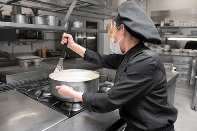 Side view of man preparing food in kitchen