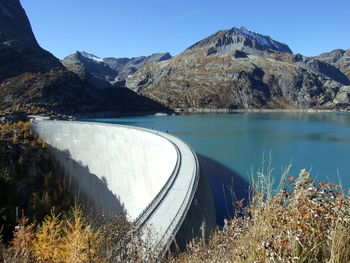 Scenic view of lake by mountains against clear sky