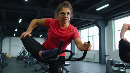 Portrait of young woman exercising in gym