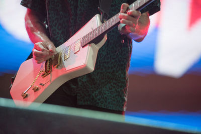 Midsection of man playing guitar