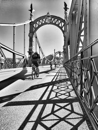 People riding bicycle on footbridge