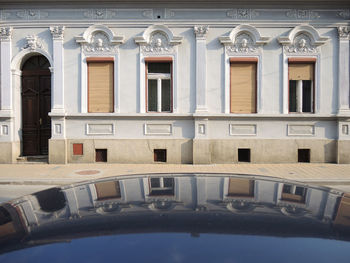 Front of house with reflection of windows on the top of the car