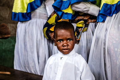 Portrait of boy standing against wall