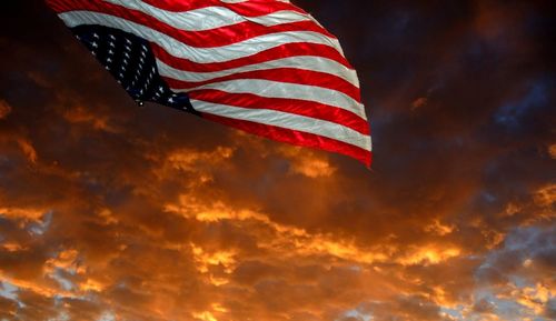 Low angle view of flag against sky during sunset