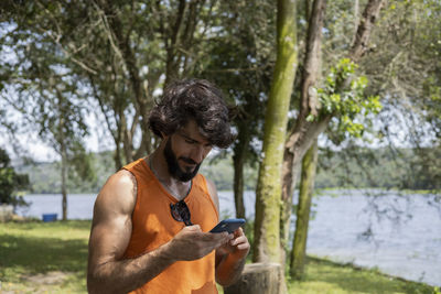 Young man at park on a beautiful sunny day with mobile phone.  working  leisure. green and nature 