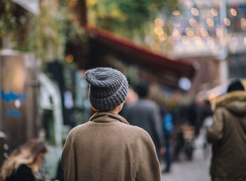 Rear view of people walking on street in city