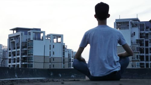 Rear view of man standing against buildings