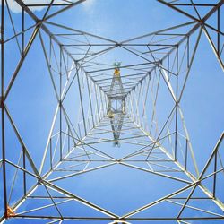 Low angle view of electricity pylon against clear blue sky