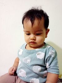 Cute boy looking away against wall