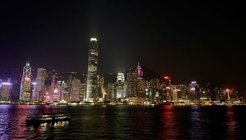 Illuminated buildings in city against sky at night