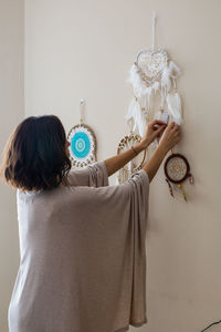 Woman decorating wall at home
