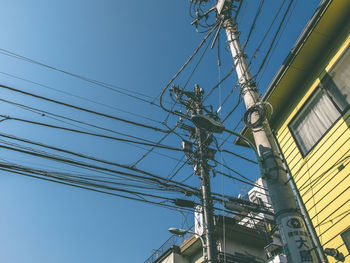 Low angle view of power lines against blue sky