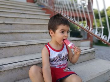 Portrait of happy boy sitting on steps