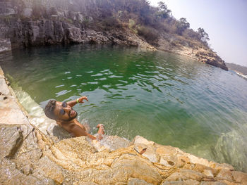 Man standing on rock by lake