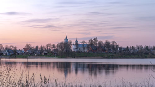 Reflection of buildings in lake at sunset