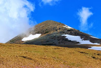 Scenic view of mountain against blue sky